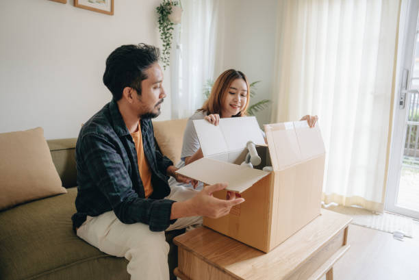 istock Young asian couple un packing boxes at home 1423389320