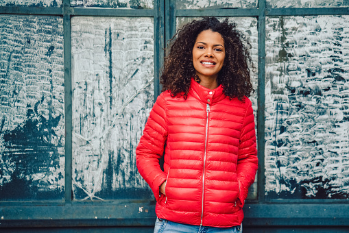 Smiling mixed race woman dressed in pink padded jacket
