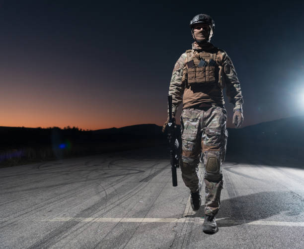 armeesoldaten in kampfuniformen mit sturmgewehr, plattenträger und kampfhelm auf eine gefährliche mission in einer regnerischen nacht. - real people caucasian one person black and white stock-fotos und bilder