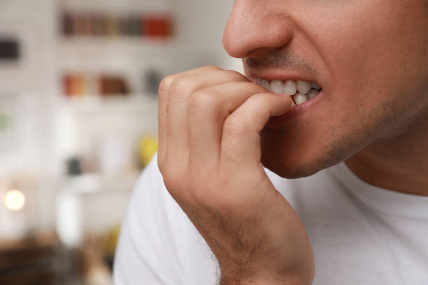 istock Man biting his nails indoors, closeup. Bad habit 1423391750
