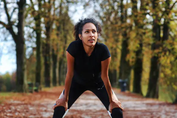 positive woman stretching outdoors preparing for exercise in sports outfit