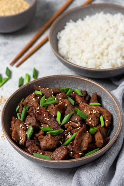 istock Korean dish Bulgogi with fried pork and rice. Gray stone background. Side view, selective focus. Asian cuisine. 1423395738