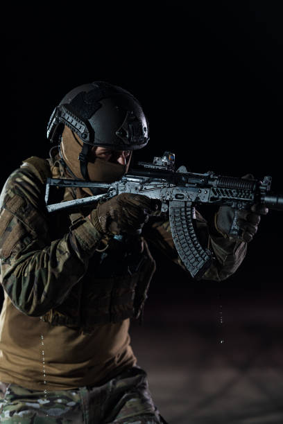 armeesoldaten in kampfuniformen mit sturmgewehr, plattenträger und kampfhelm auf eine gefährliche mission in einer regnerischen nacht. - real people caucasian one person black and white stock-fotos und bilder