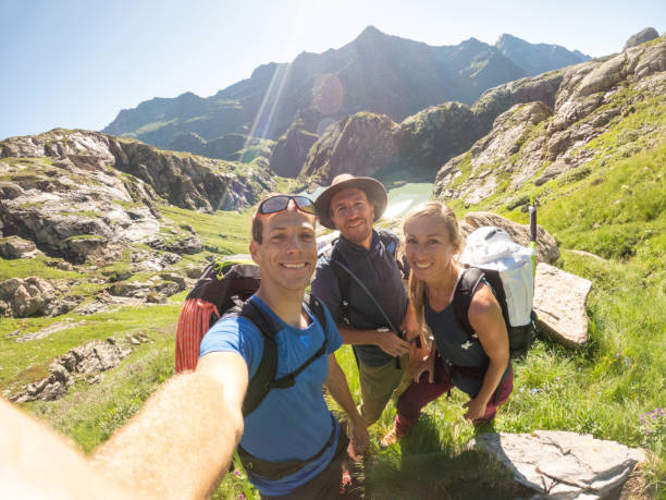 istock Group of hikers walking on trail and taking a selfie 1423395999