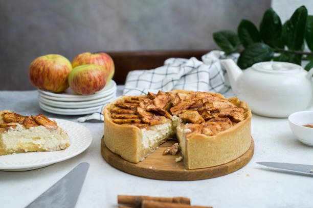 istock Apple pie with cinnamon and piece of apple pie on white plate on gray background 1423397100