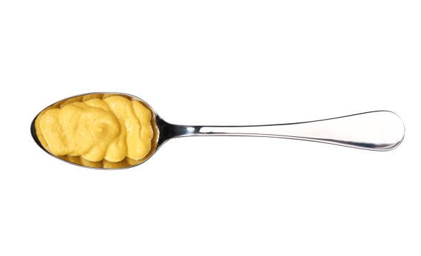 istock Mustard sauce in small metal spoon  isolated on white background,top view 1423397697
