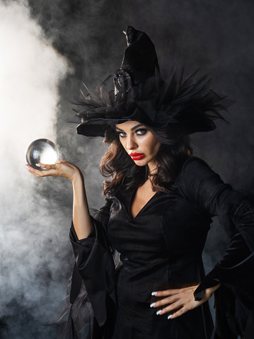 Young woman with crystal ball. Fortune telling. Halloween party costume