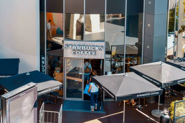 starbucks, eine internationale kaffeehauskette, die an der nasdaq-börse notiert ist. sie wurde 1971 in seattle, washington, usa, gegründet. - starbucks coffee bean editorial stock-fotos und bilder