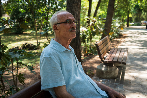 Senior man relaxing at park bench