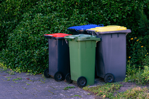 Wheelie bins on a pavement waiting for rubbish collection, UK.