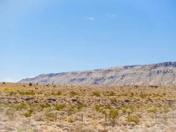 Long ridge beyond flat desert landscape.