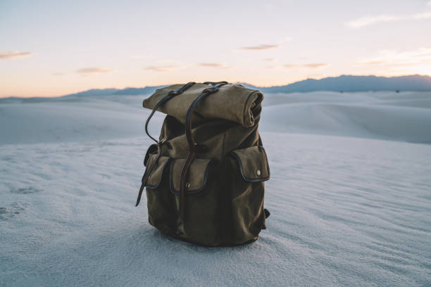 istock Khaki backpack with equipment and pockets on sand 1423407580