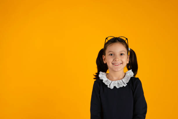 Schoolgirl against yellow background.