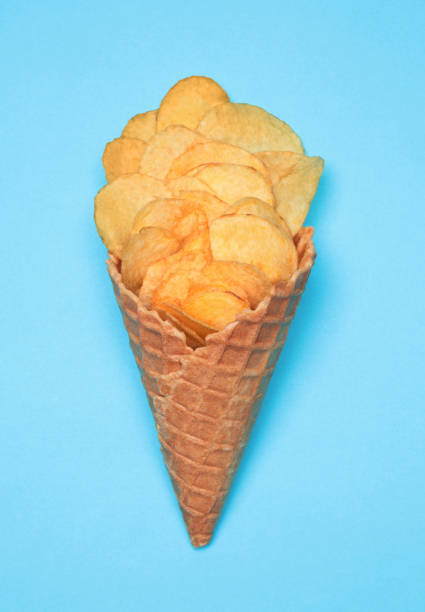 Waffle Cone with Potato Chips on blue background. Fast Food concept stock photo