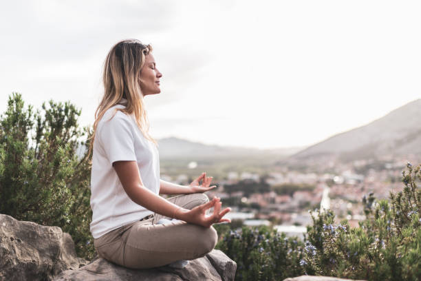 istock Young woman preforms yoga in mountains at sunset 1423410336