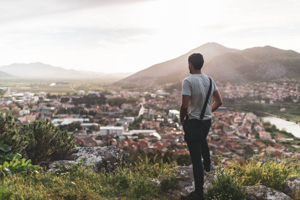 istock Young man breathing fresh air in mountains at sunset 1423410489