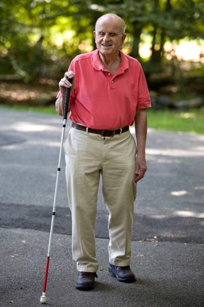 istock Blind person smiling walking with cane in park 1423410800