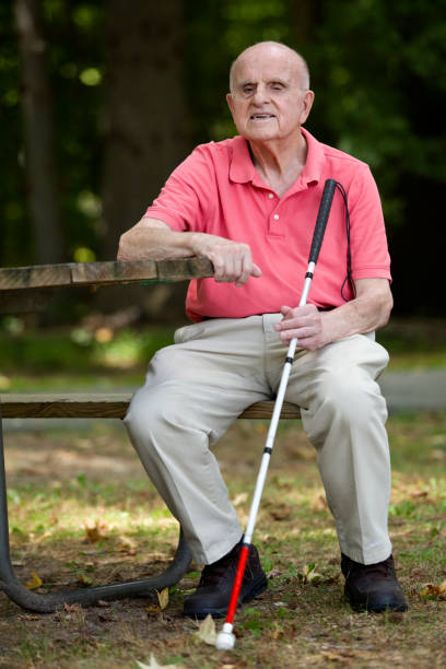 istock Blind person with smile sitting with walking stick 1423410856