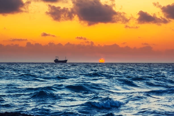 Seascape with cargo ship in sunset time, in the Mediterranean Sea