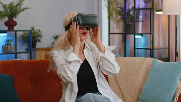 istock Senior woman use virtual reality futuristic technology headset play simulation 3D video game at home 1423414064