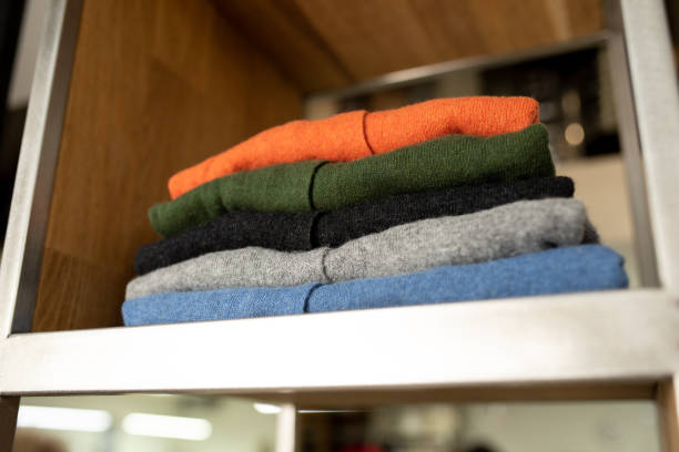 istock Stack of colorful sweaters on store shelf 1423416777