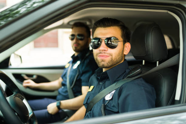 istock Attractive policeman looking at the camera while in the patrol car 1423420144