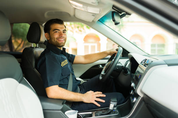 istock Policeman looking at the camera while driving the patrol car 1423420156