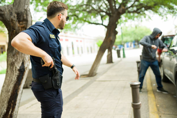 istock Cop getting ready to use his gun arresting a robber 1423420228
