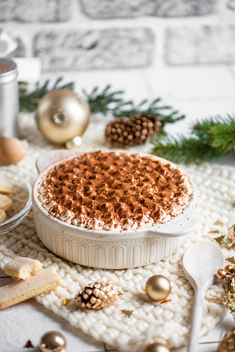 istock Festive Christmas Dessert Tiramisu sponge cake in bright rustic kitchen with golden Christmas Ornaments 1423422307