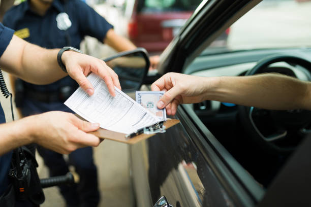 closeup of police officers receiving a bribe for a speeding ticket - speeding ticket imagens e fotografias de stock