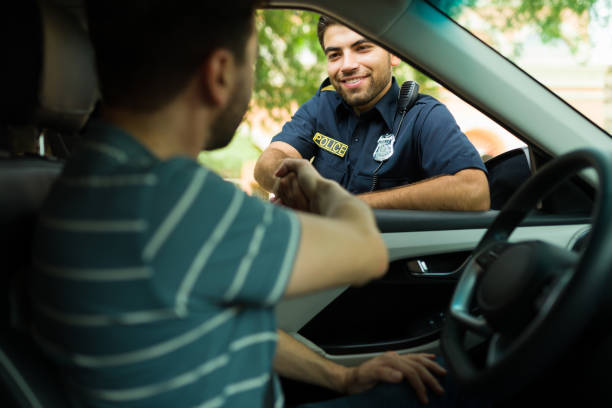istock Cheerful police agent talking with a driver 1423424633