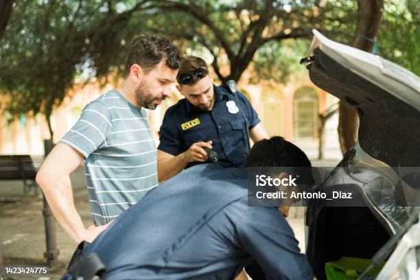 Police Agents Looking For Guns Or Drugs In The Car Trunk Stock Photo - Download Image Now