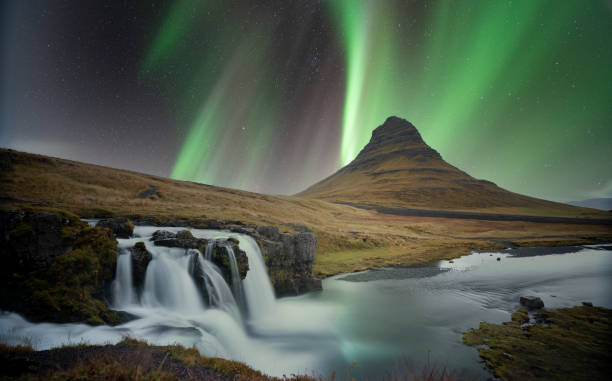 montaña kirkjufell y kirkjufellsfoss con auroras boreales en islandia - dramatic sky iceland landscape sky fotografías e imágenes de stock