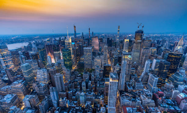 manhattan midtown ao pôr do sol com uma vista do empire state building - night empire state building building exterior horizontal - fotografias e filmes do acervo