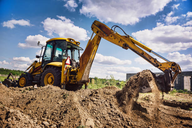 Excavator at house construction site - digging foundations for modern house Excavator working at house construction site - digging foundations for modern house. Beginning of house building. Earth moving and foundation preparation. mechanical digger stock pictures, royalty-free photos & images