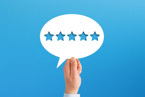 istock The best rating. Hand holding five star shape in speech bubble on blue background. 1423431111