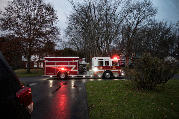 istock Fire Engine with Flashing Emergency Lights Rushing Through Suburban Neighborhood 1423432193