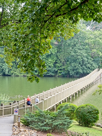 A couple walks across the pedestrian bridge crossing lake Junaluska in western North Carolina, August 2002.