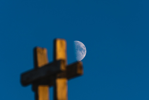 image of half moon and construction plank. the moon is photographed at the end of the scaffolding.