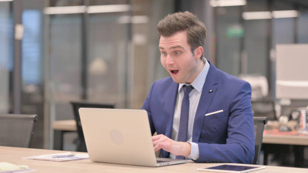 istock Businessman Celebrating Success while using Laptop in Office 1423436087