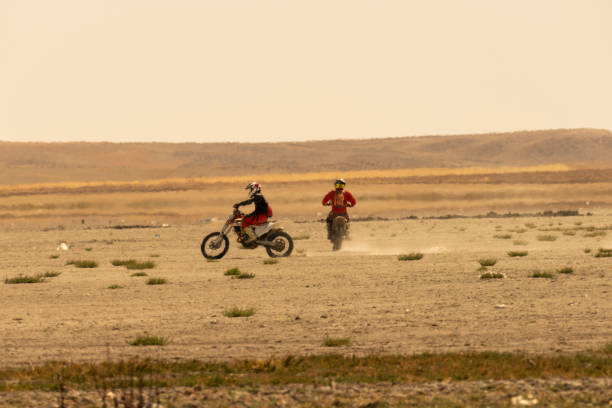 Two dirt bike riders on a dirt race track.
