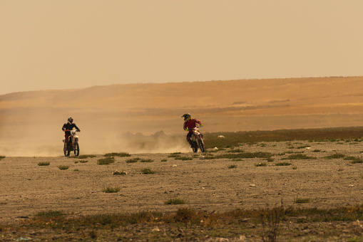 motor racing on the steppe on a hot and sunny day. Bikers were seen in the mirage caused by the extreme heat. Shot with a full frame camera.