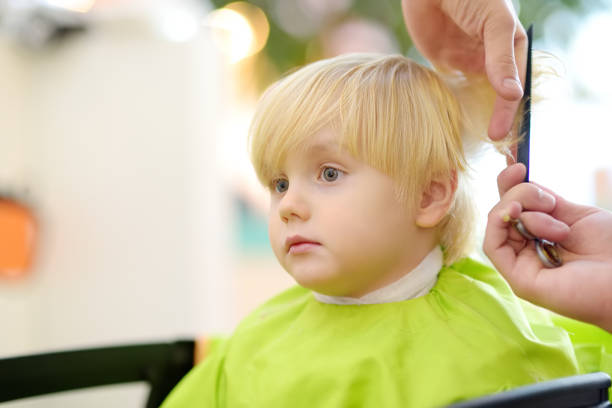 niño preescolar que se corta el pelo. peluquería infantil con herramientas profesionales - peine y tijeras. - 13576 fotografías e imágenes de stock