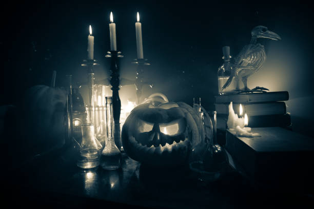 Halloween still-life background with different elements on dark toned foggy background. Selective focus stock photo