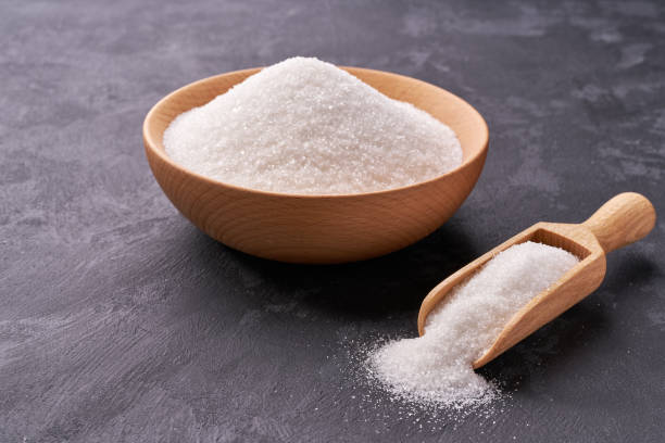 istock Wooden bowl and scoop with white sugar  on on a black background 1423442500