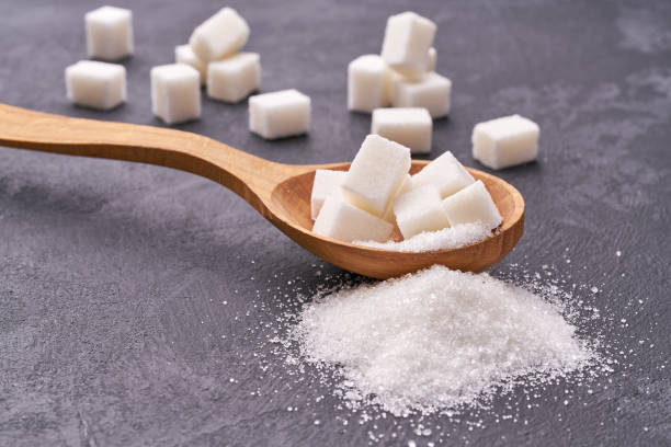 istock white sugar in wooden spoon on black table 1423442514