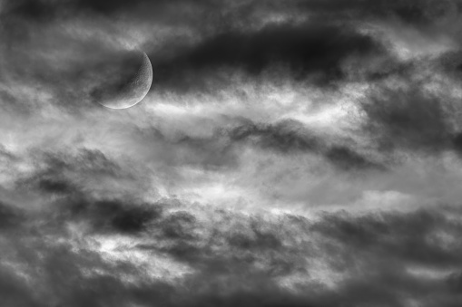 The Moon Is Rising Among A Colorful Cloud Filled Sunset Sky Black And White