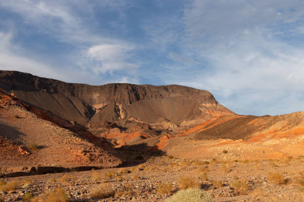 istock Las Vegas, Nevada, USA - August 17, 2022: Wispy clouds pepper deep blue evening sky over ancient red volcanic rock formations within Lake Mead recreation area 1423448424