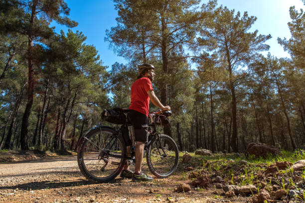 Vintage bicycle parked on a forest trail surrounded by trees. Old style bicycle resting on a sunlit woodland path symbolizing outdoor adventure and eco friendly travel.