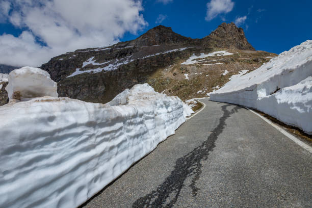 estrada montanhosa alpina entre a neve na primavera, gran paradiso alpes, itália - melting spring snow trentino alto adige - fotografias e filmes do acervo